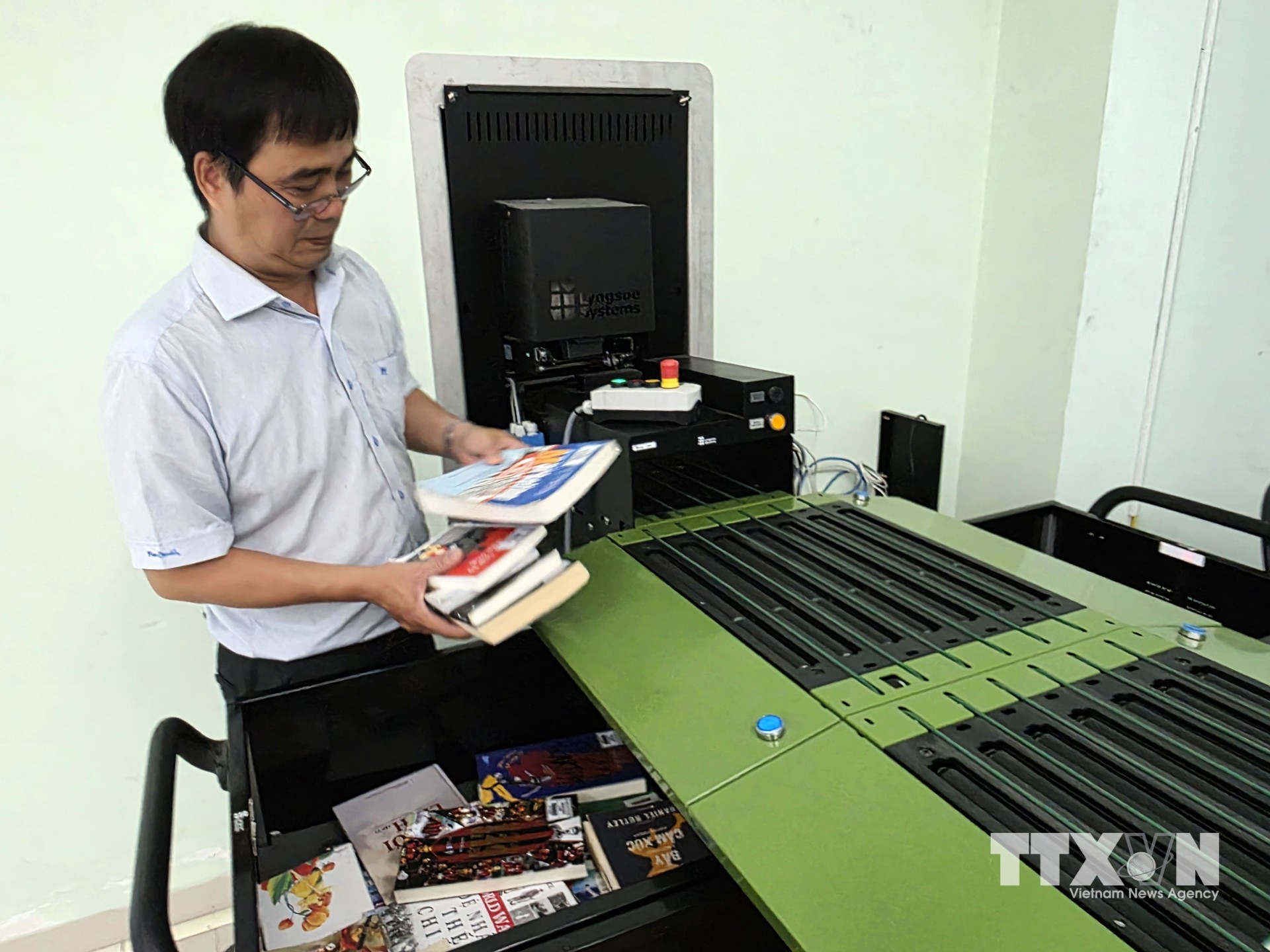 Nhân viên thư viện kiểm tra sách tại hệ thống xử lý tài liệu tự động, hỗ trợ nâng cao hiệu quả quản lý và phục vụ bạn đọc. (Ảnh: Trần Lê Lâm/TTXVN)